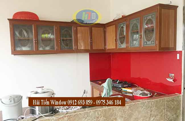 Tủ bếp nhôm kính vân gỗ nhạt và kính ốp bếp màu đỏ sang trọng